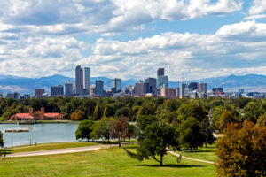 Denver skyline across a lake with trees on a beautiful autumn day